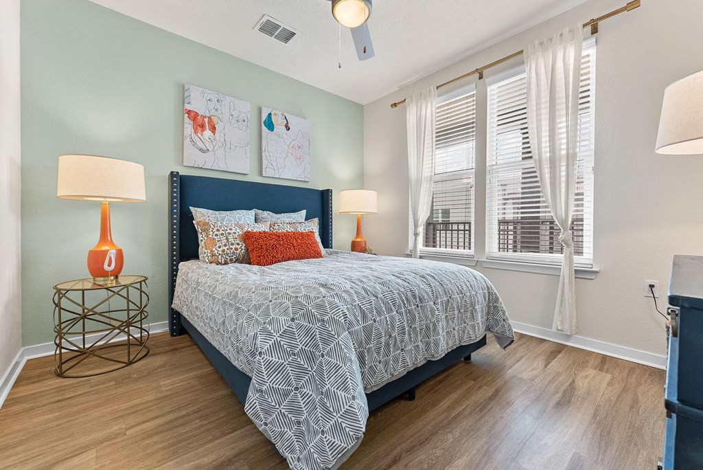 a bedroom with a bed and two windows