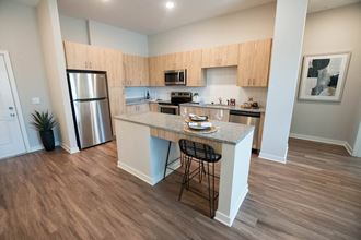 a kitchen with an island and a stainless steel refrigerator