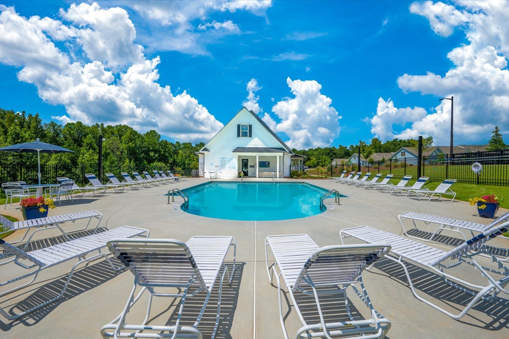 the swimming pool at the retreat at thousand oaks apartments with white chairs around it