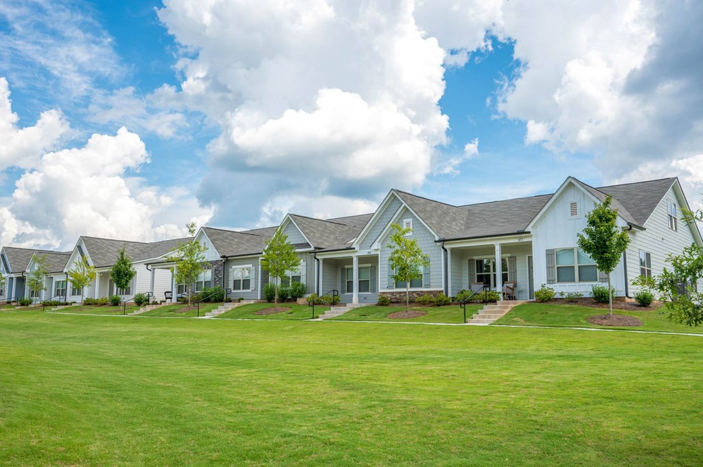 a row of houses with a green lawn in front of them