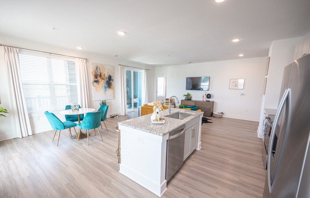 a kitchen with an island and a dining room with a table and chairs