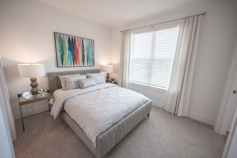 a bedroom with a bed and a large window