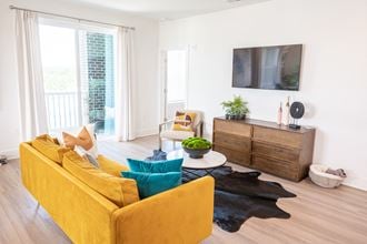 a living room with a yellow couch and a tv