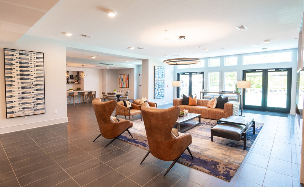 a living room with couches chairs and a table    and a kitchen