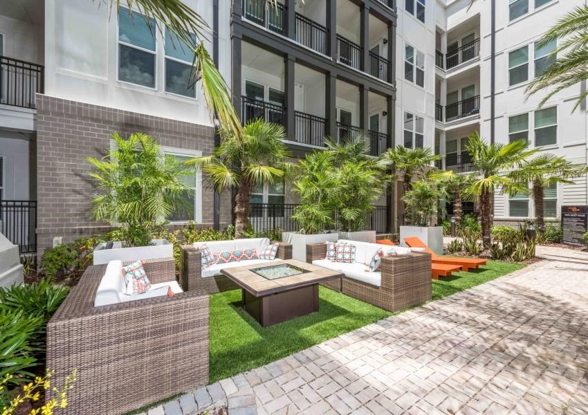 an outdoor living area with couches and a table in front of an apartment building