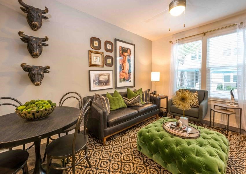 a living room with a green couch and a dining room table