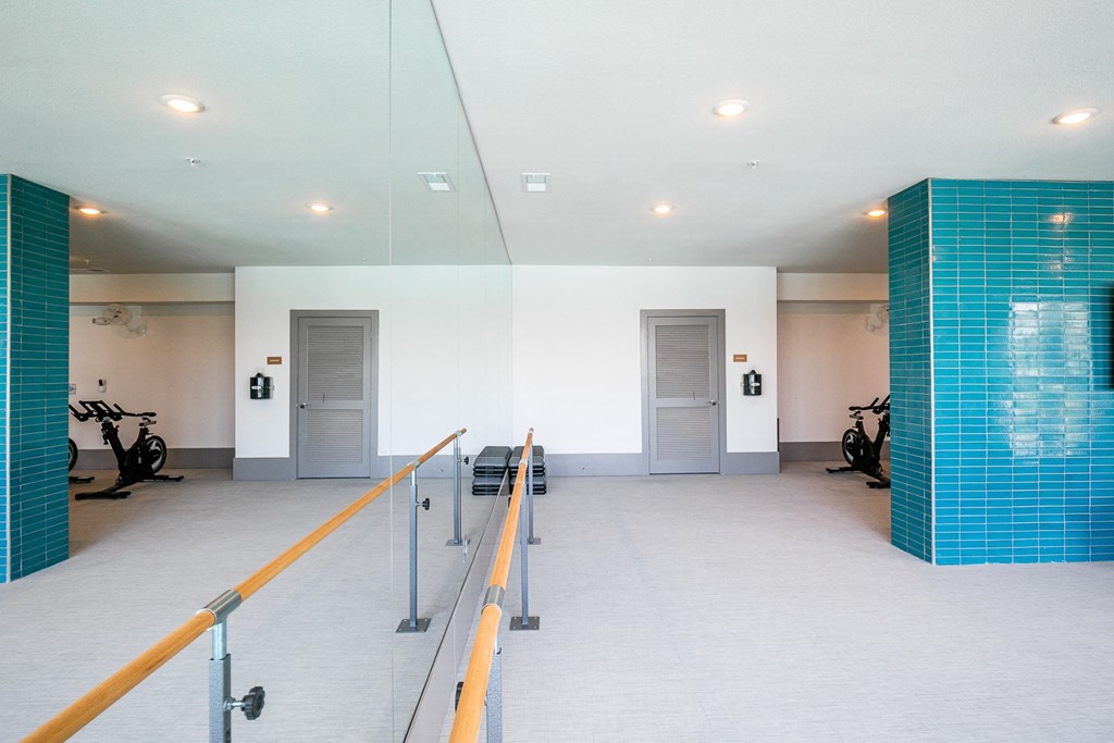 a large white room with two doors and blue tile on the walls