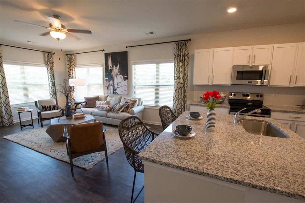 a kitchen and living room with a granite counter top