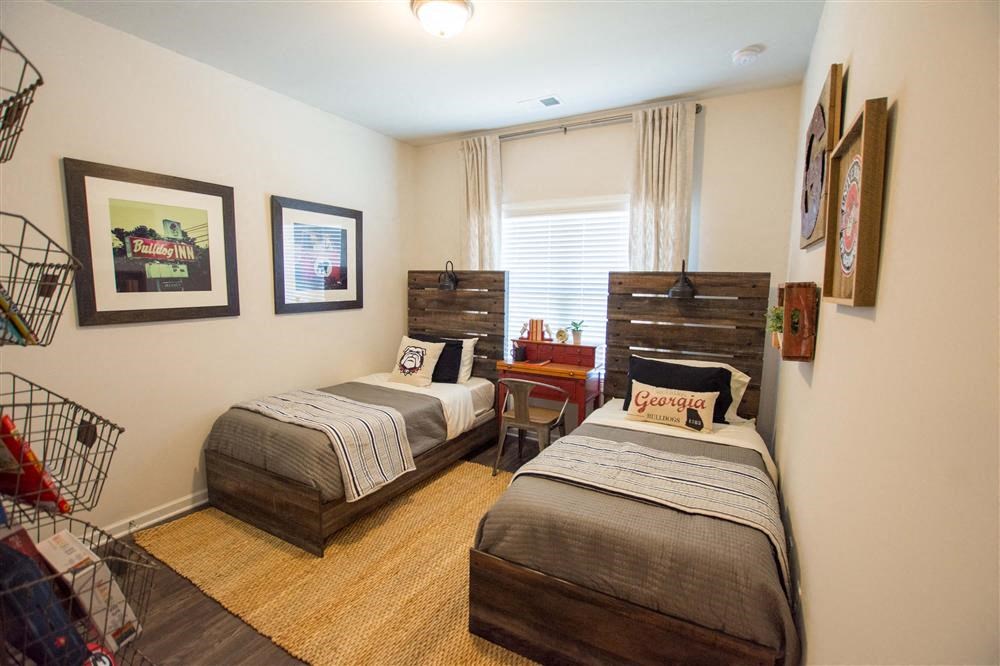 a bedroom with two beds and a table and a window