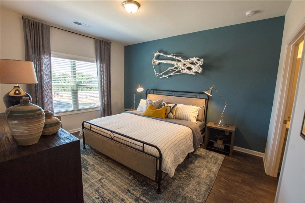 a bedroom with a bed and a blue accent wall