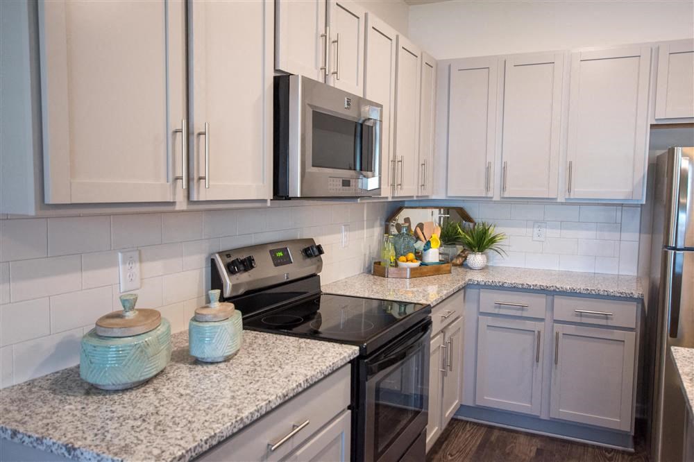 a kitchen with white cabinets and a black stove