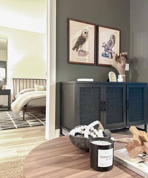 A room with a wooden table and a cabinet with a bowl on it.