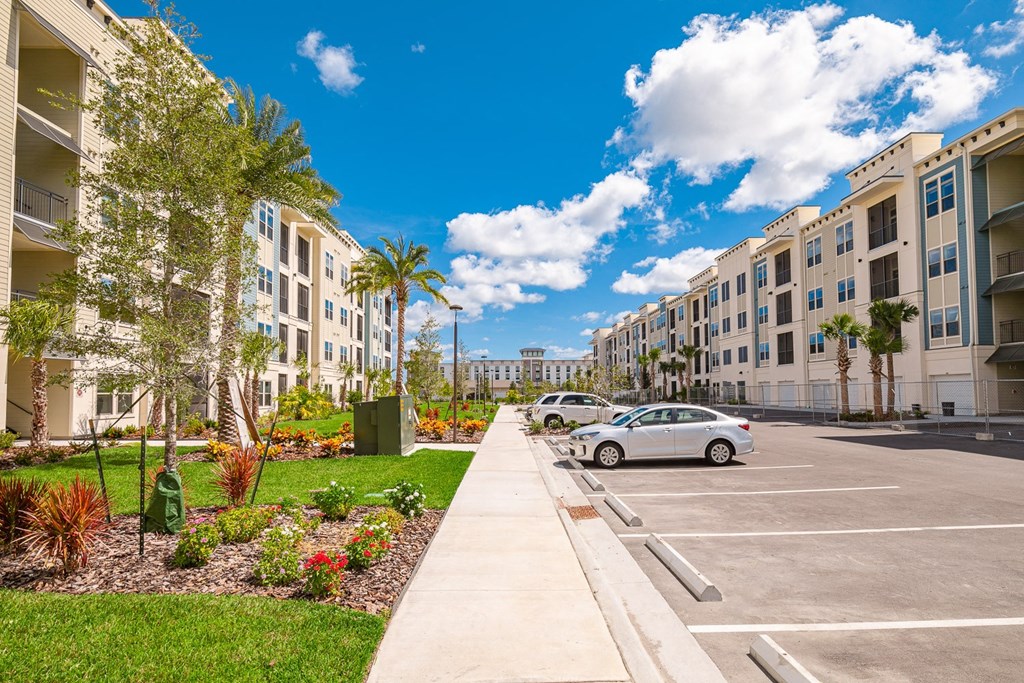a parking lot with cars in front of some apartments