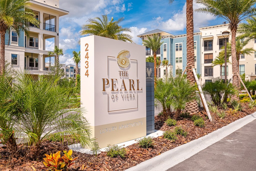 the pearl of west sign in front of an apartment building
