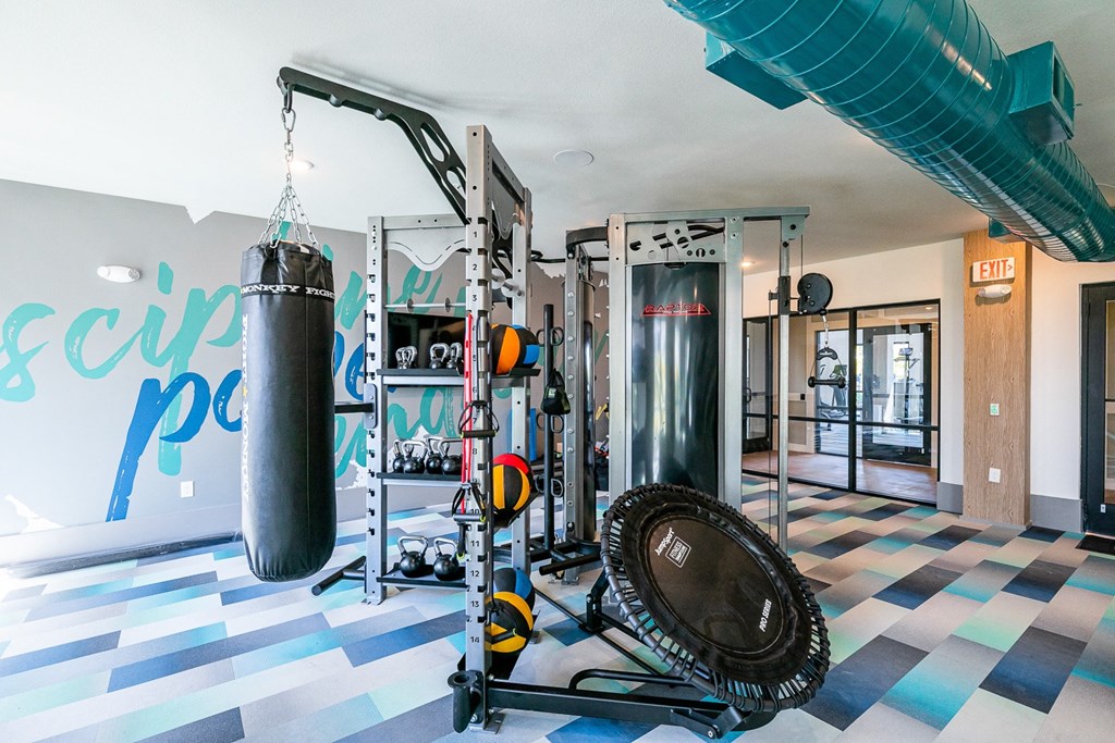 a gym with a punching bag and weights on the floor