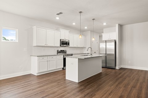 a kitchen with white cabinets and a stainless steel refrigerator