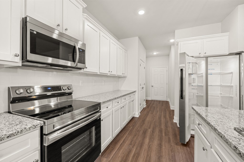 a kitchen with white cabinets and stainless steel appliances