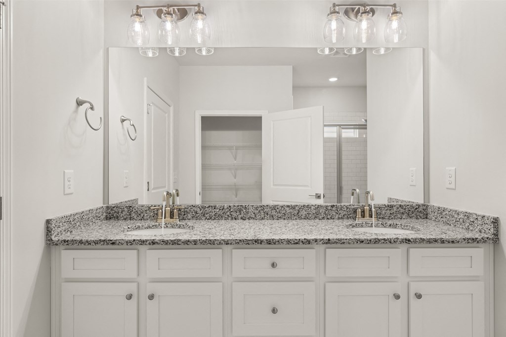 a bathroom with white cabinets and granite counter tops