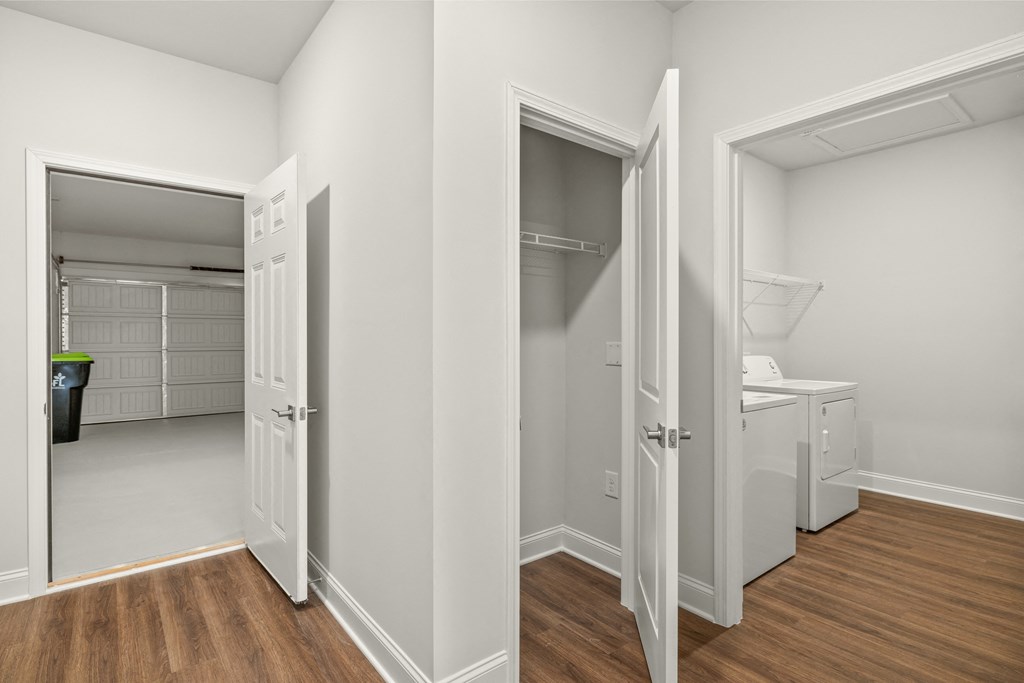 a bedroom and a hallway with doors to a closet and a laundry room