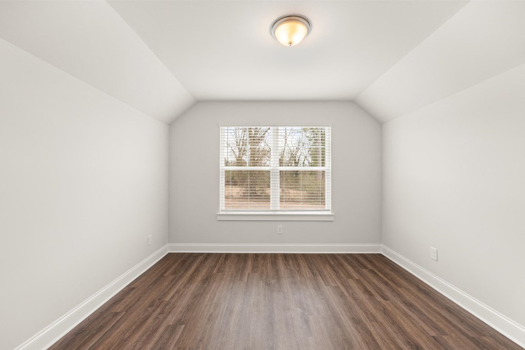 an empty room with wood floors and a window