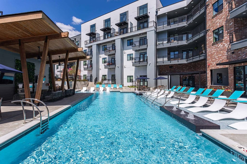 a swimming pool with lounge chairs next to an apartment buildingat Sterling Nashville West Apartments, Nashville, TN