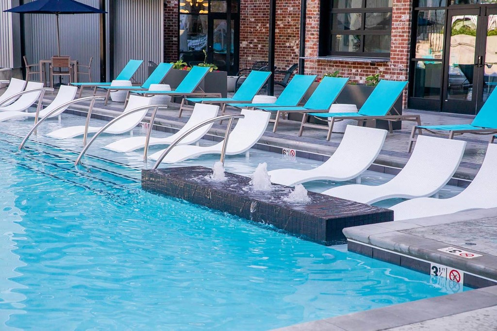 a swimming pool with white and blue chairs next to itat Sterling Nashville West Apartments, Nashville, TN