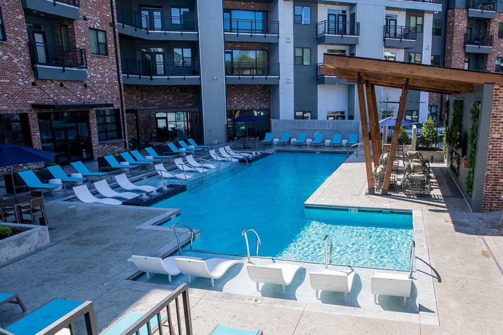A large swimming pool with lounge chairs and a wooden pergola at Sterling Nashville West Apartments, Tennessee, 37209