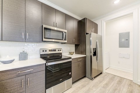 a modern kitchen with stainless steel appliances and dark wood cabinets