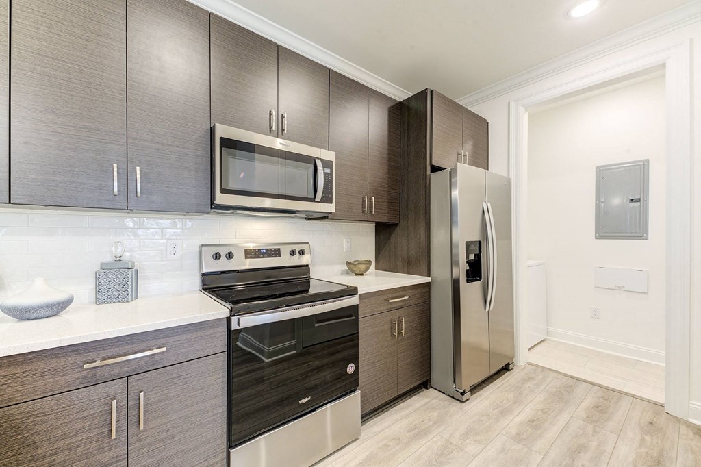a modern kitchen with stainless steel appliances and dark wood cabinets