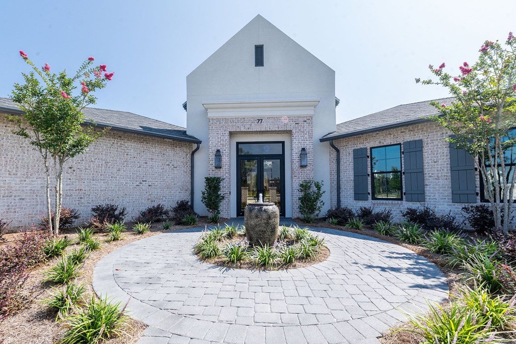 the front of a house with a courtyard and a fountain