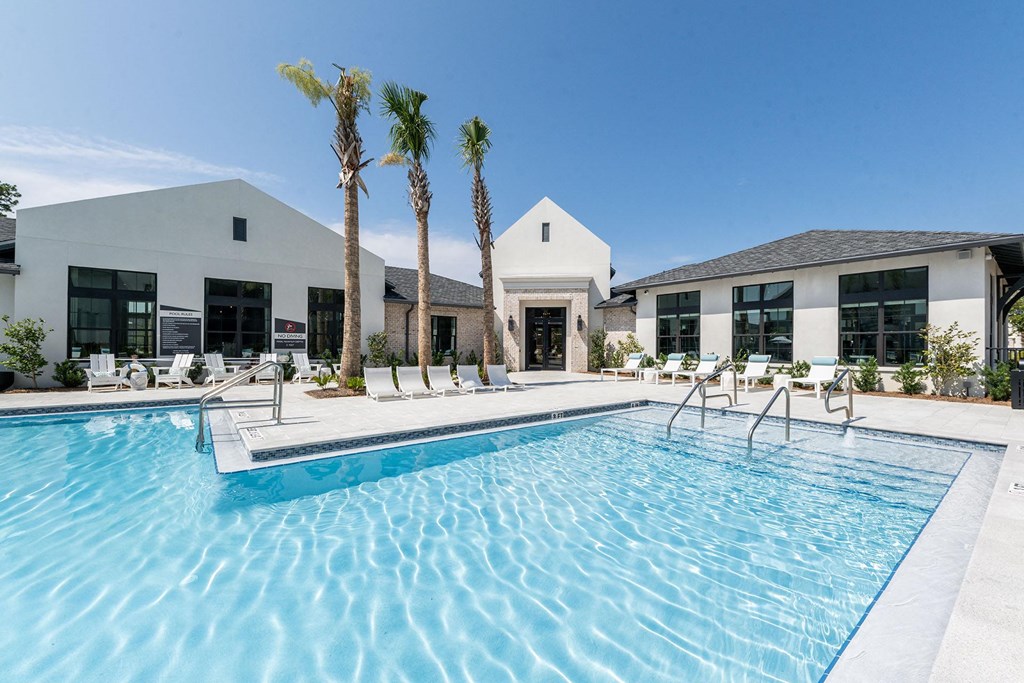 a swimming pool with palm trees in front of a building