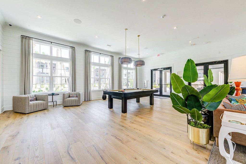 a large living room with a pool table in the middle