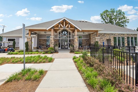 the front of a building with a walkway and a gate