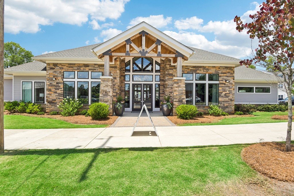 the front of a building with a sidewalk and grass