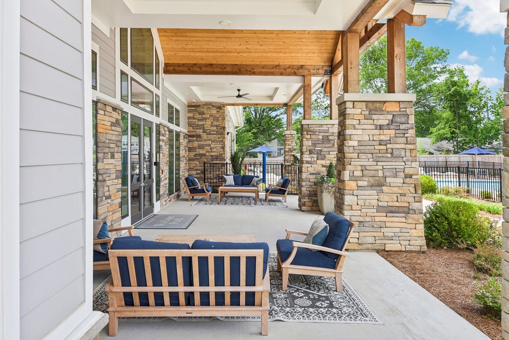 the front porch of a home with rocking chairs and a covered patio