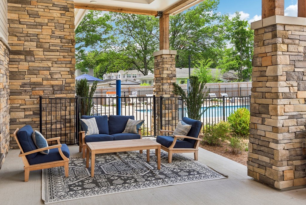 a patio with furniture and a pool in the background