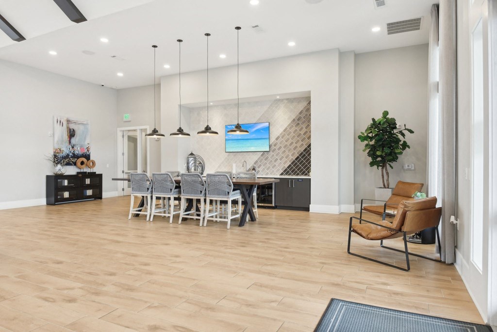 the living room and dining room of a house with white walls and wood flooring