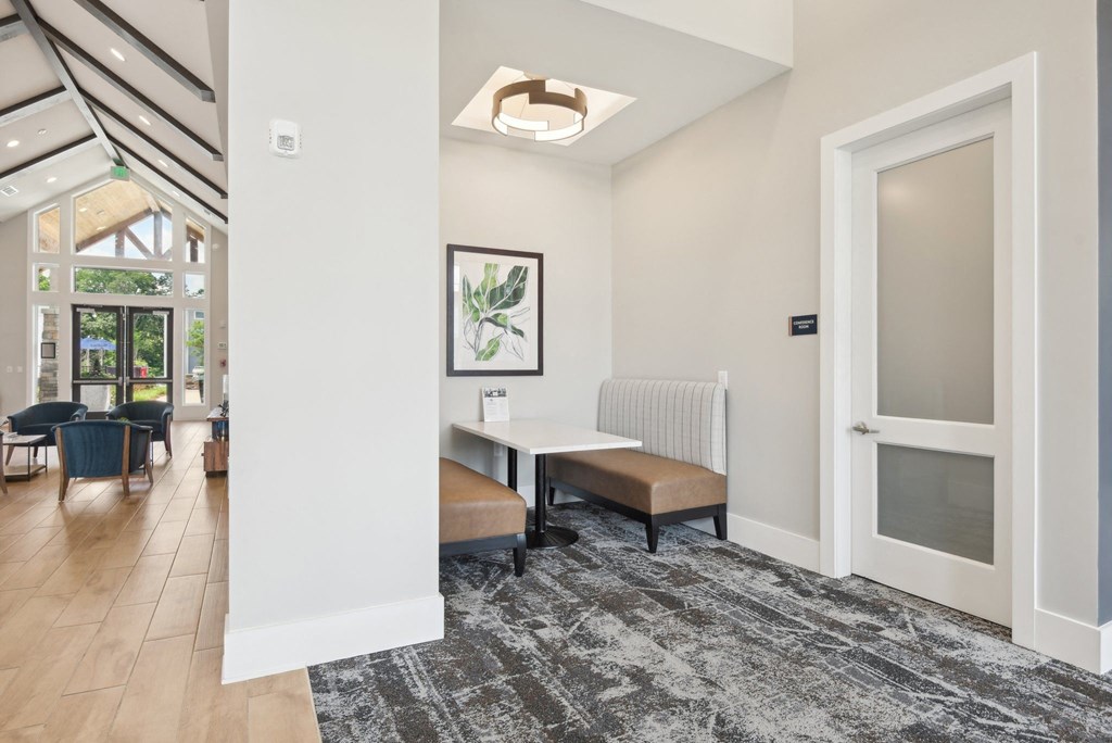 a dining room with a table and chairs and a door to a living room