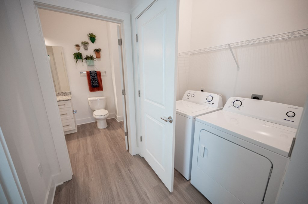 a laundry room with a washer and dryer and a bathroom with a toilet