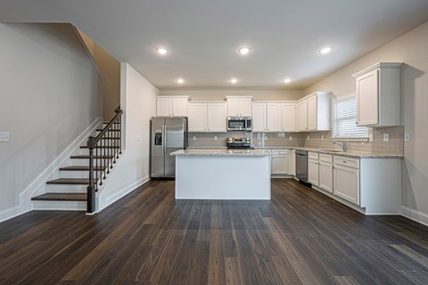 a kitchen with white cabinets and a white island in the middle