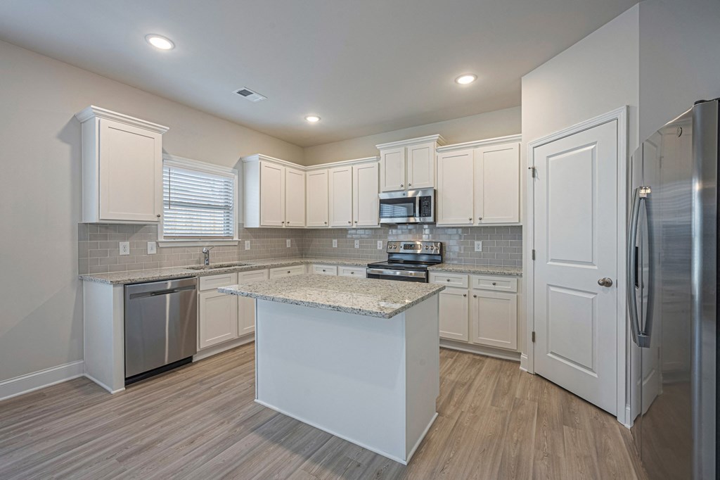 a kitchen with white cabinets and stainless steel appliances