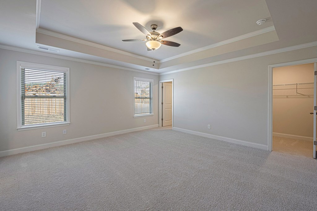 an empty living room with a ceiling fan and a window