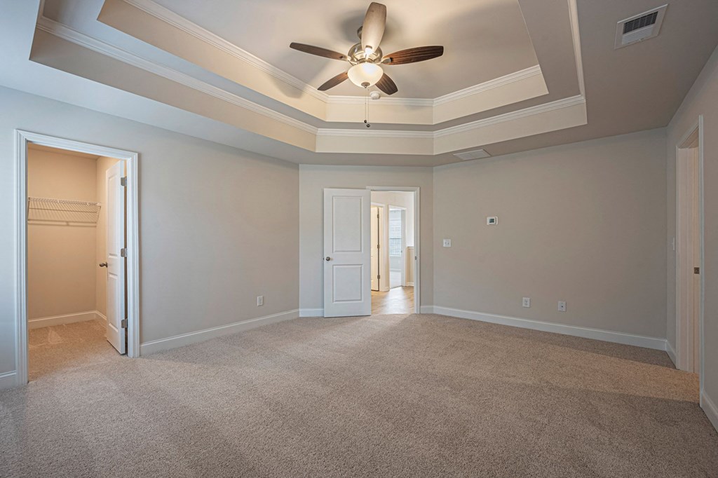 an empty living room with a ceiling fan