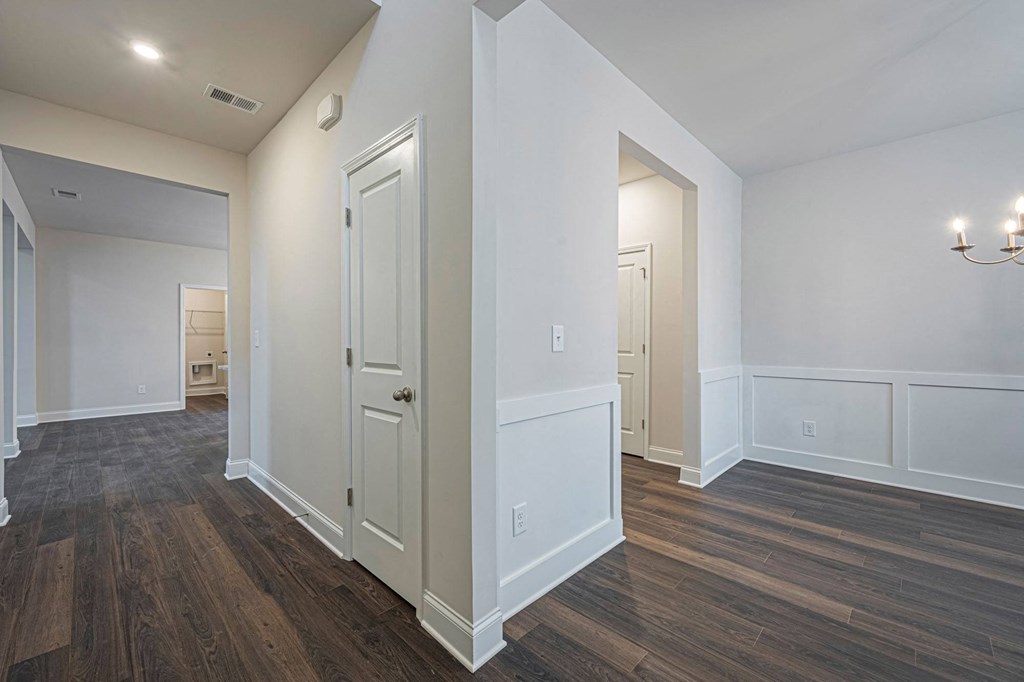 a renovated living room with white walls and wood flooring