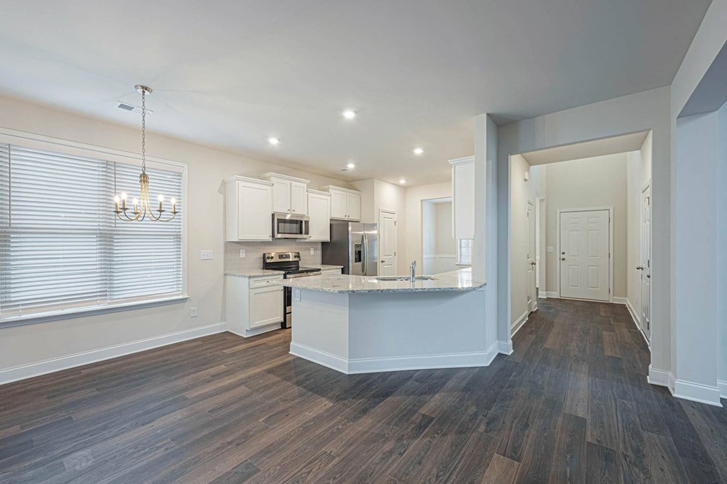 a kitchen with white cabinets and a large island in the middle