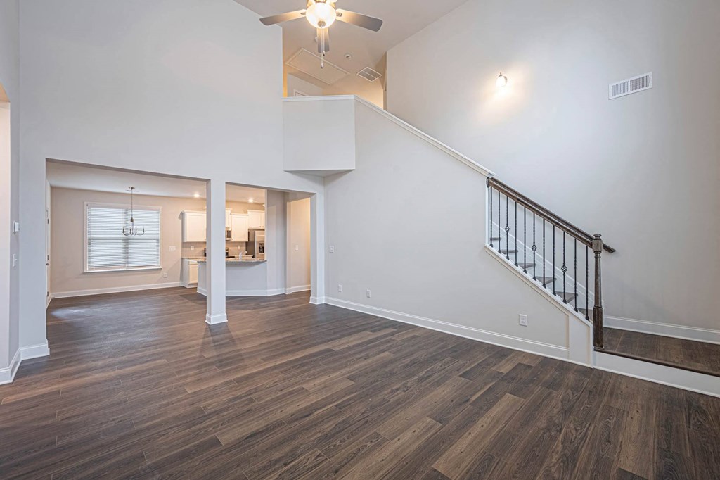 a living room with a staircase and a ceiling fan