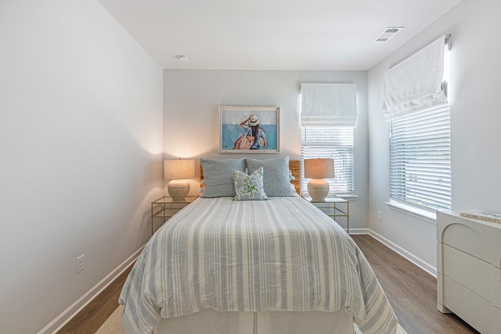 a bedroom with a bed and two windows