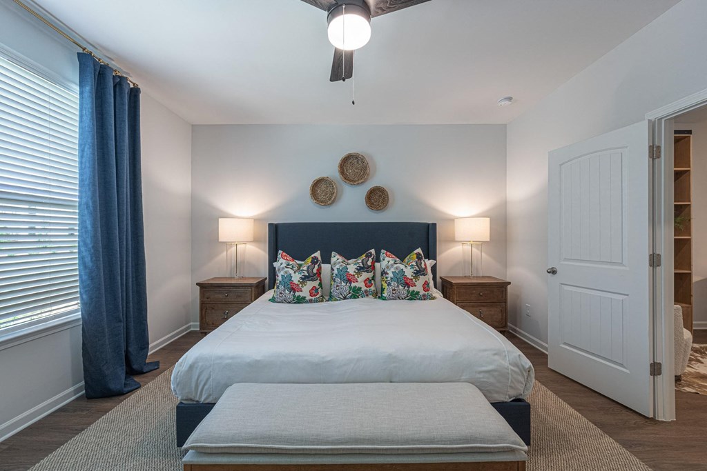 a bedroom with a large bed and a ceiling fan