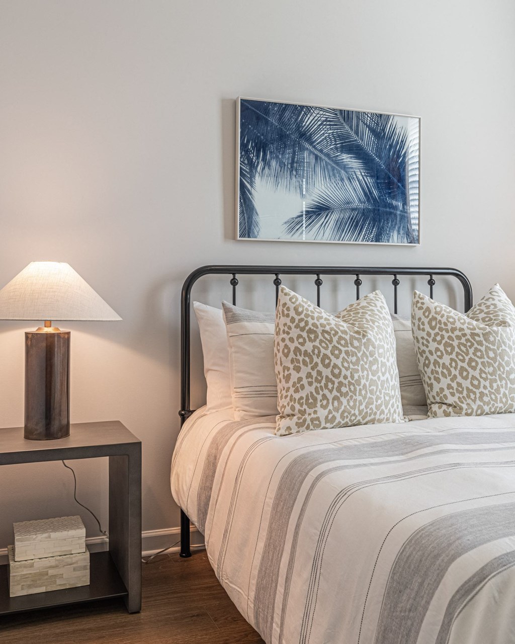 a bedroom with a bed and a picture of a palm tree