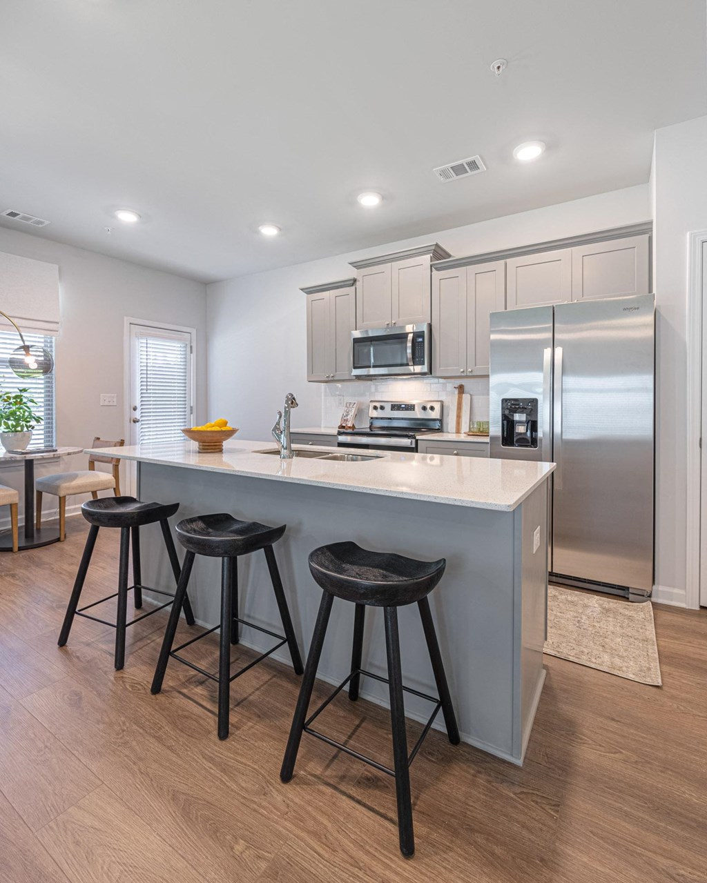 a kitchen with a large island with three stools